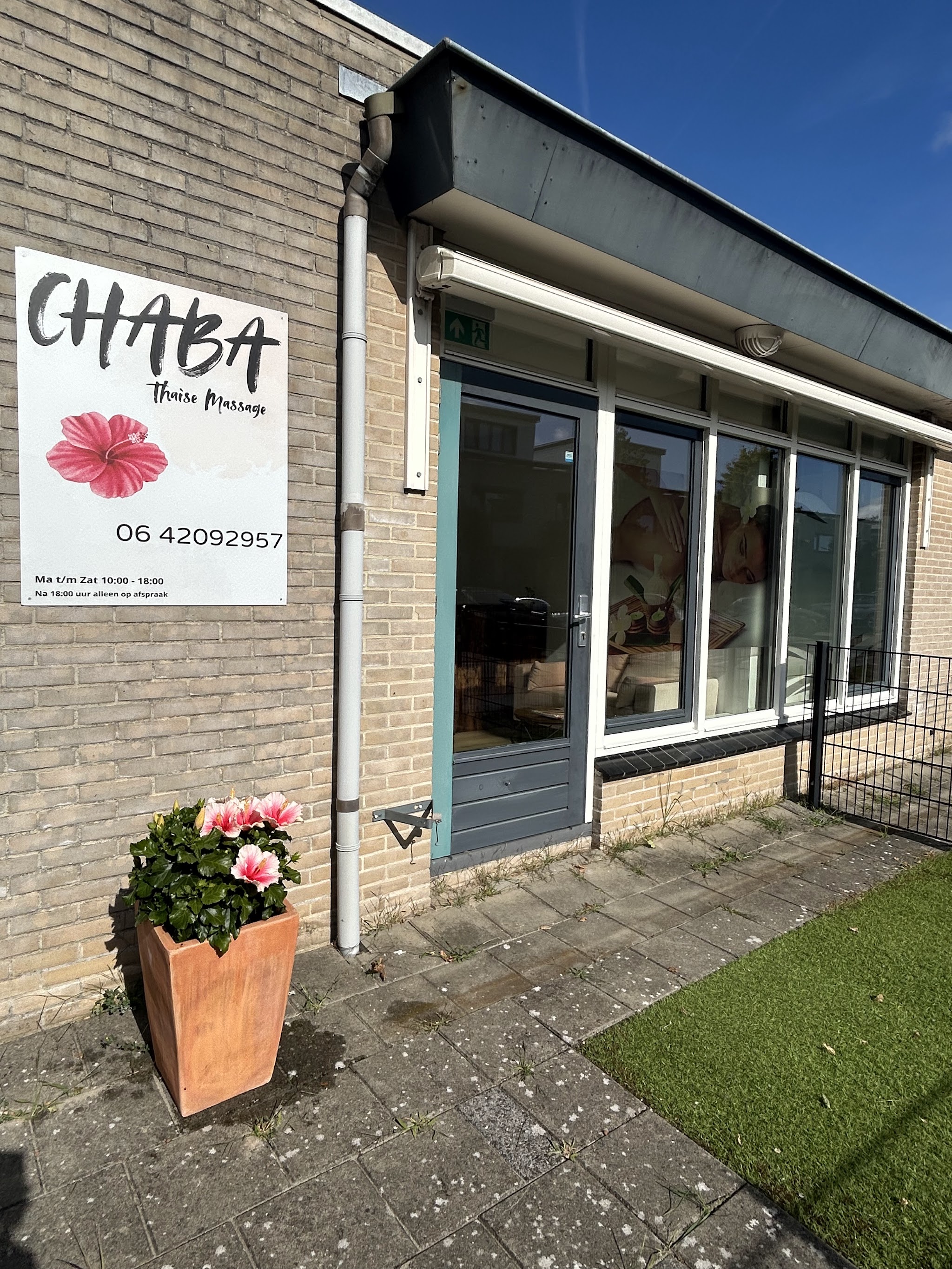 De ingang van Chaba aan de Terschellingstraat, met het bord aan de gevel en een hibiscus in een pot